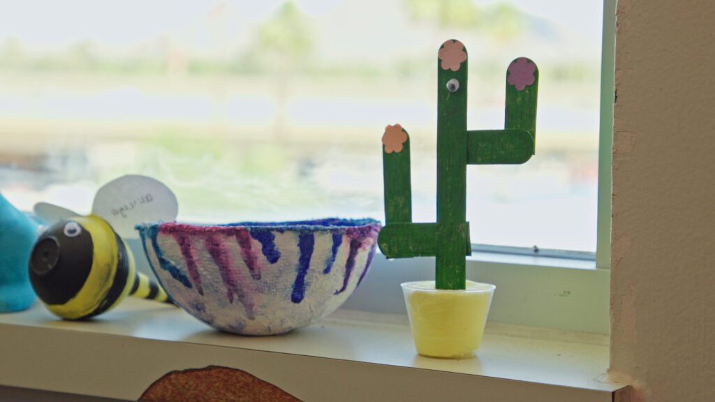 An image of a cactus, bowl, and bumble bee that a patient created out of common art materials such as popsicle sticks.