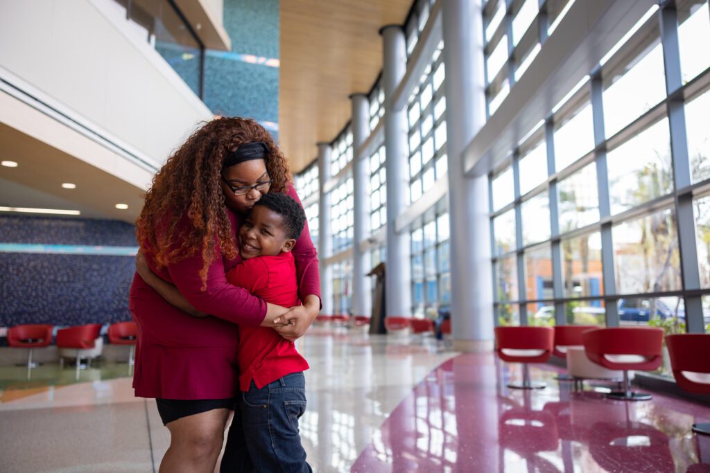A mother hugs her child in the lobby of Phoenix Children's.