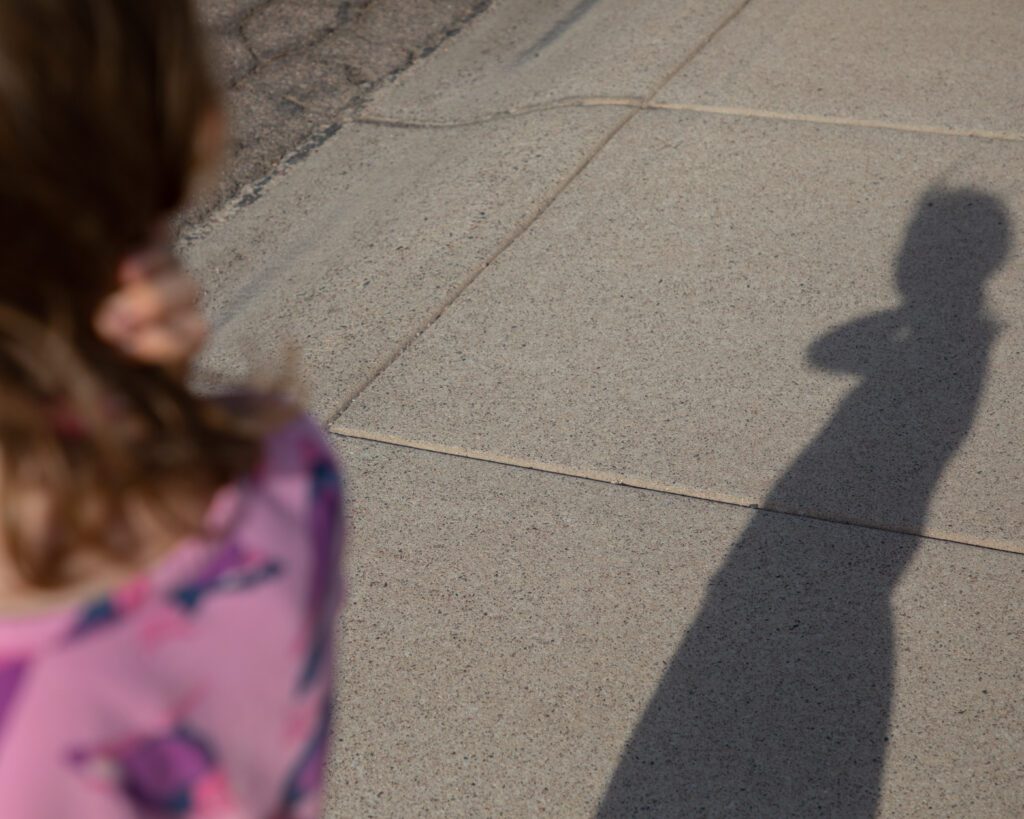 An image of a girl's shadow on the sidewalk
