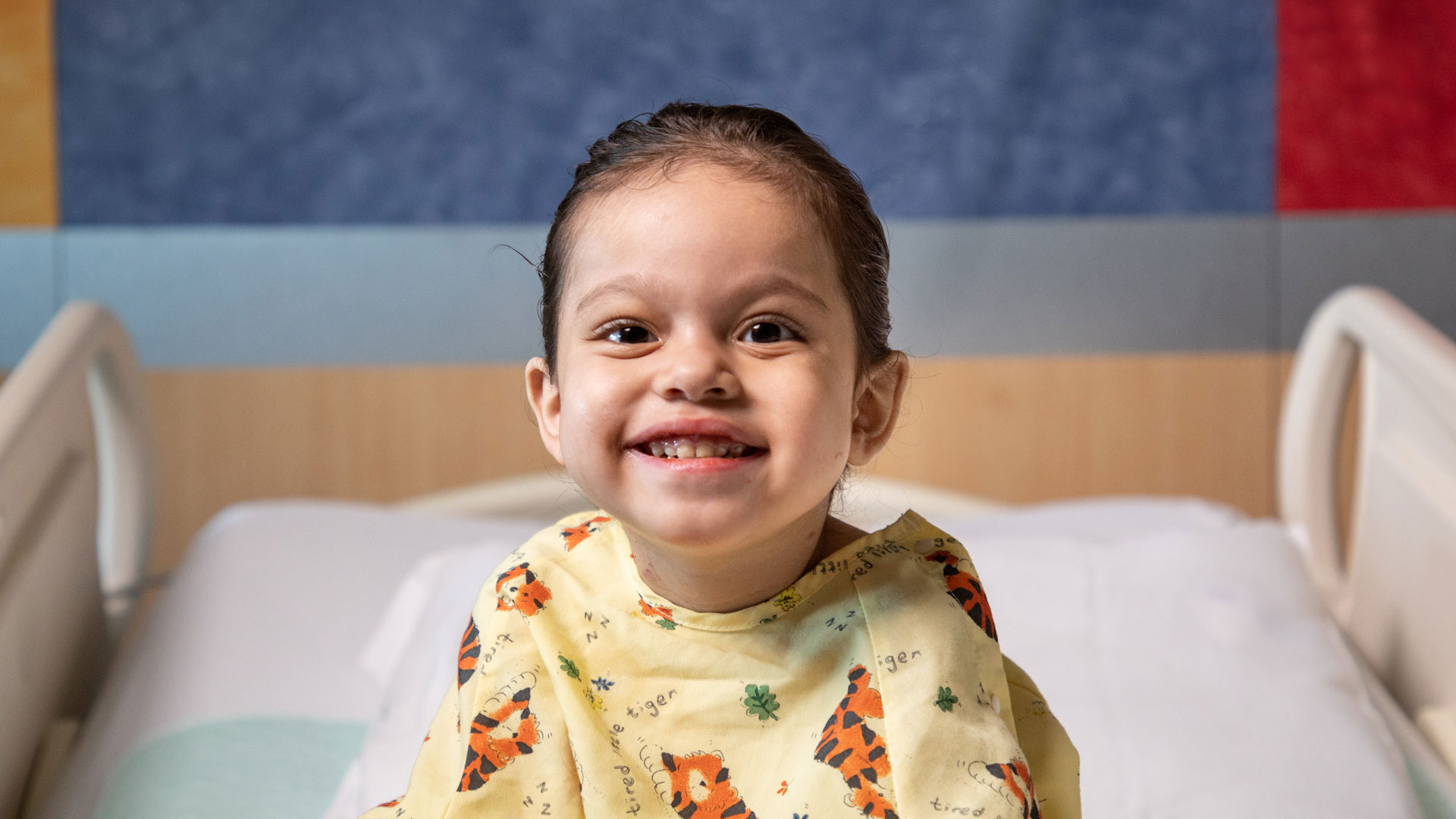 Namiko smiles wide on her hospital bed.