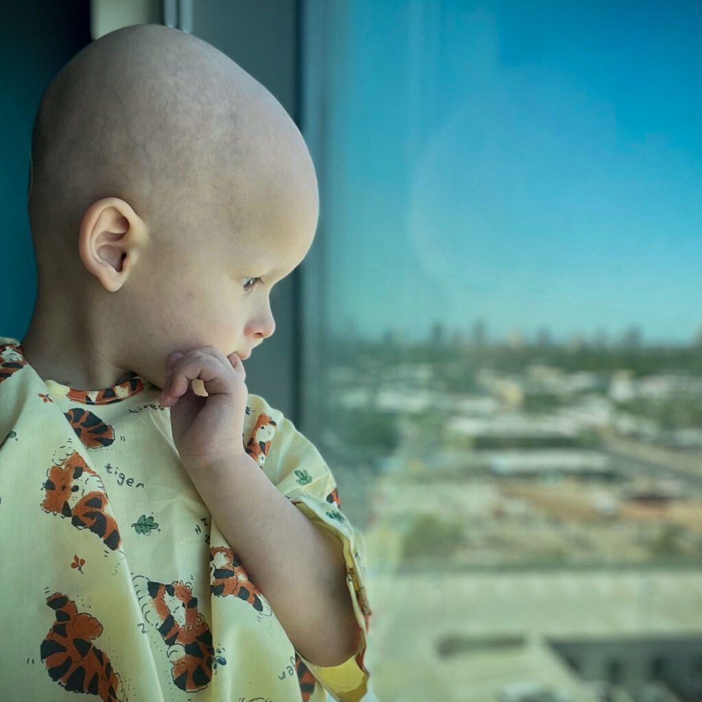 Nash stares out his hospital window. At this point, he has no hair