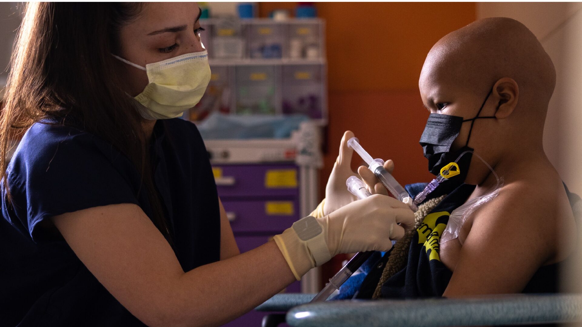 A nurse administers chemotherapy to a child.