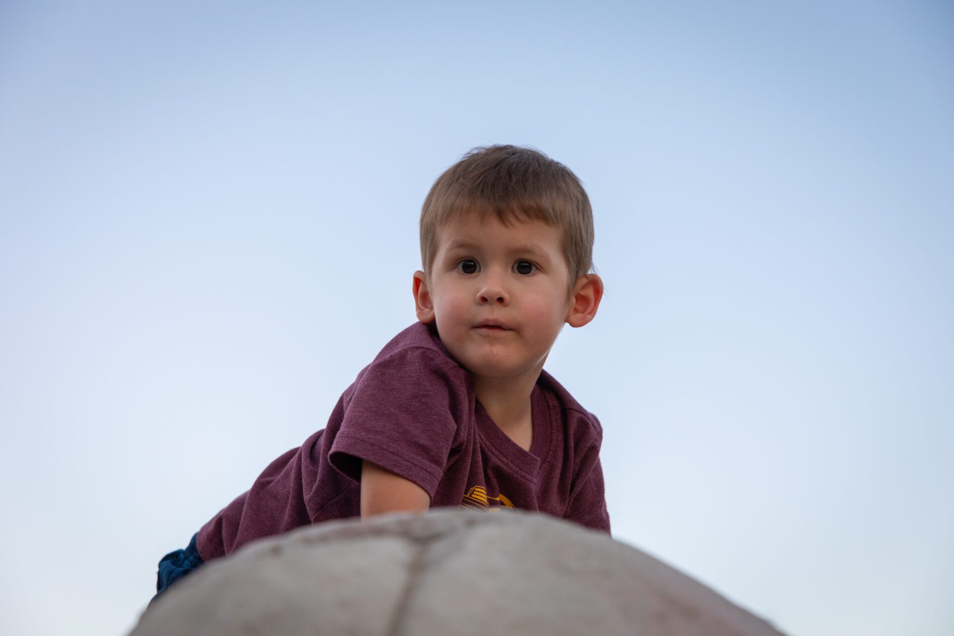 Nash poses for a photo on top of a rock climbing wall.
