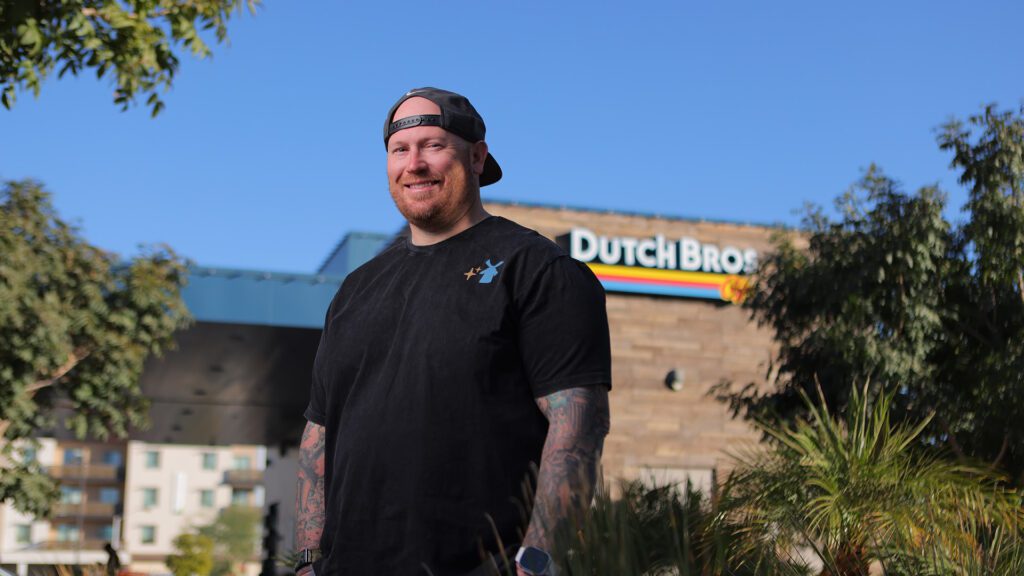 Josh Hayes poses for a photo outside of a Dutch Bros location he manages in the Valley.