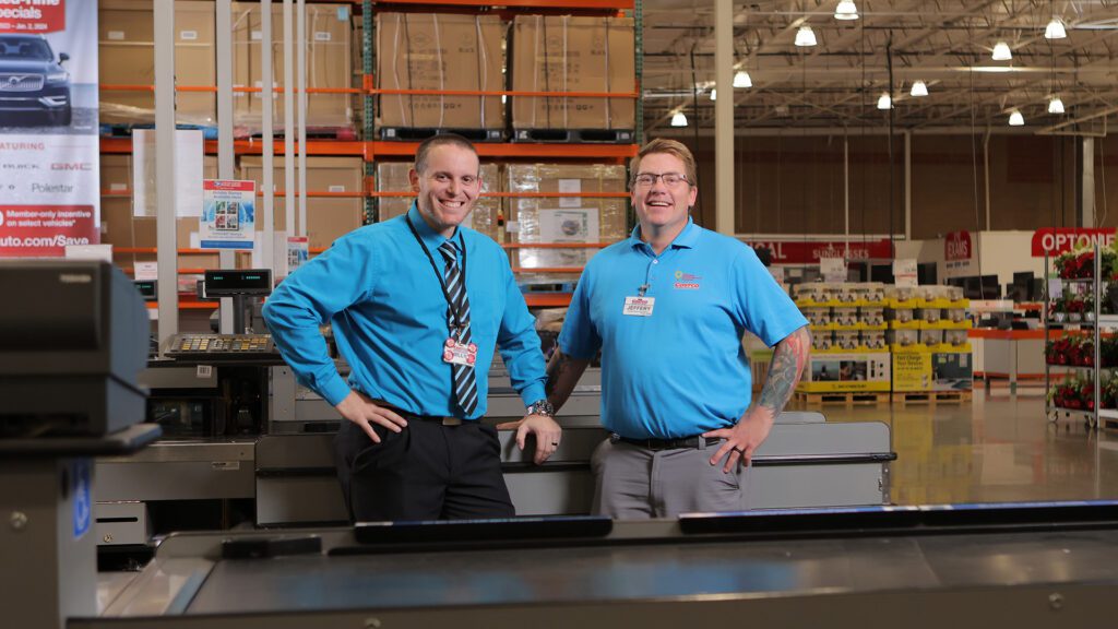 Billy Loss and Jeff Tilghman pose for a photo in front of one of Costco's check out registers.
