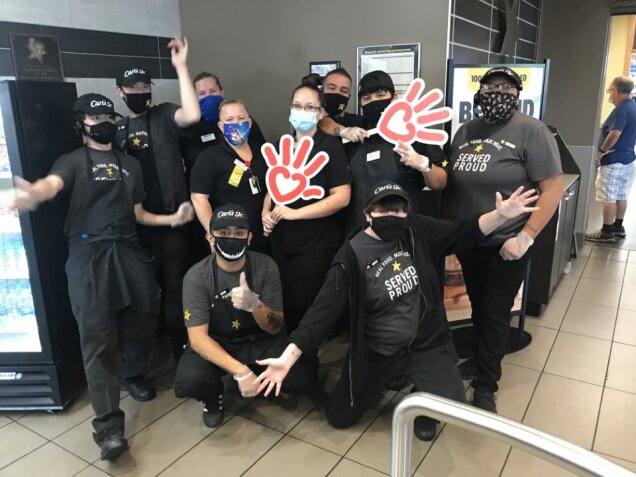 Carl's Jr. employees gather for a photo while holding up the Phoenix Children's handprint logos