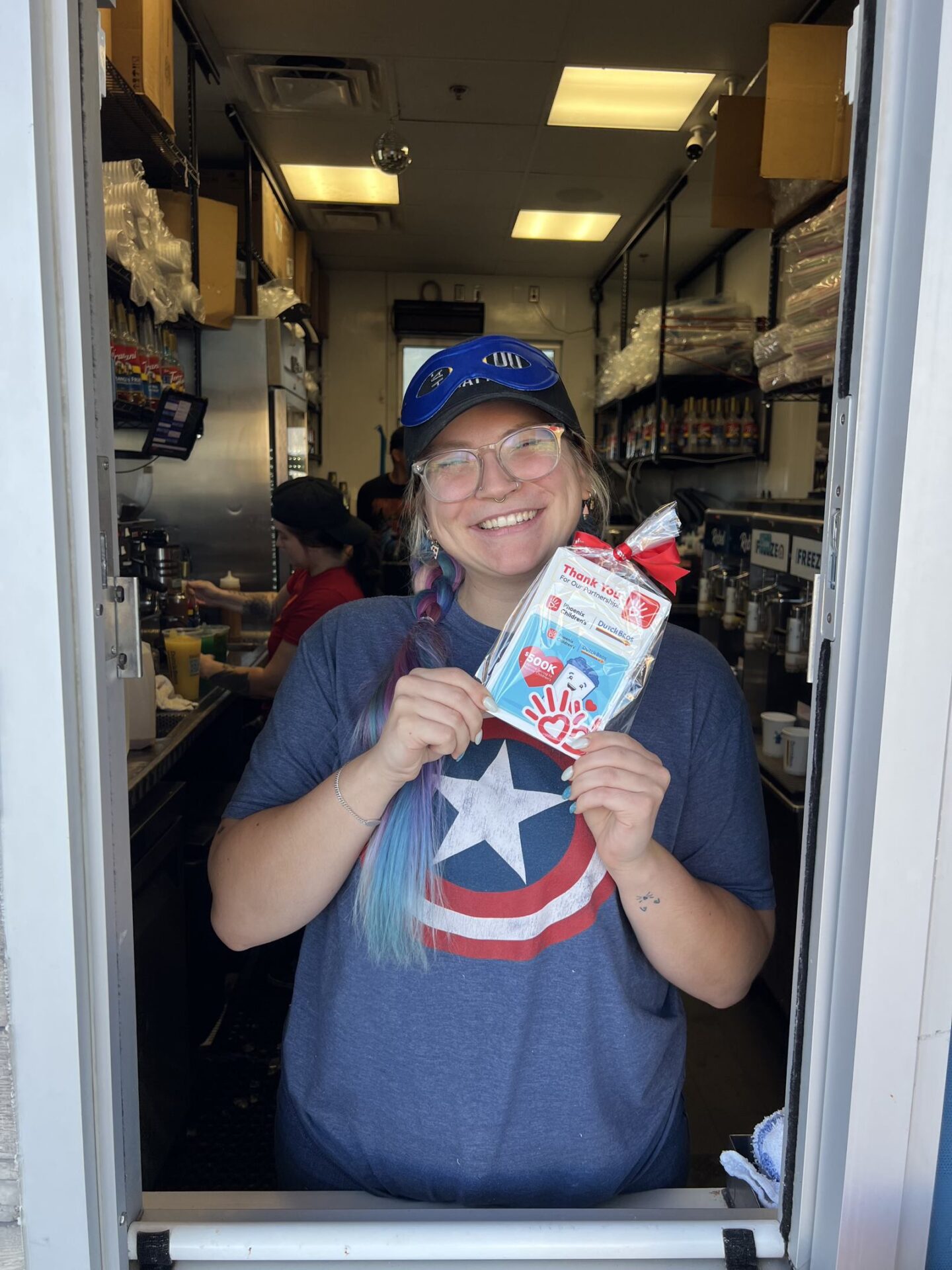 A Dutch Bros employee holds up a thank you gift from Phoenix Children's given those who donate at the Dutch Bros drive through line. 