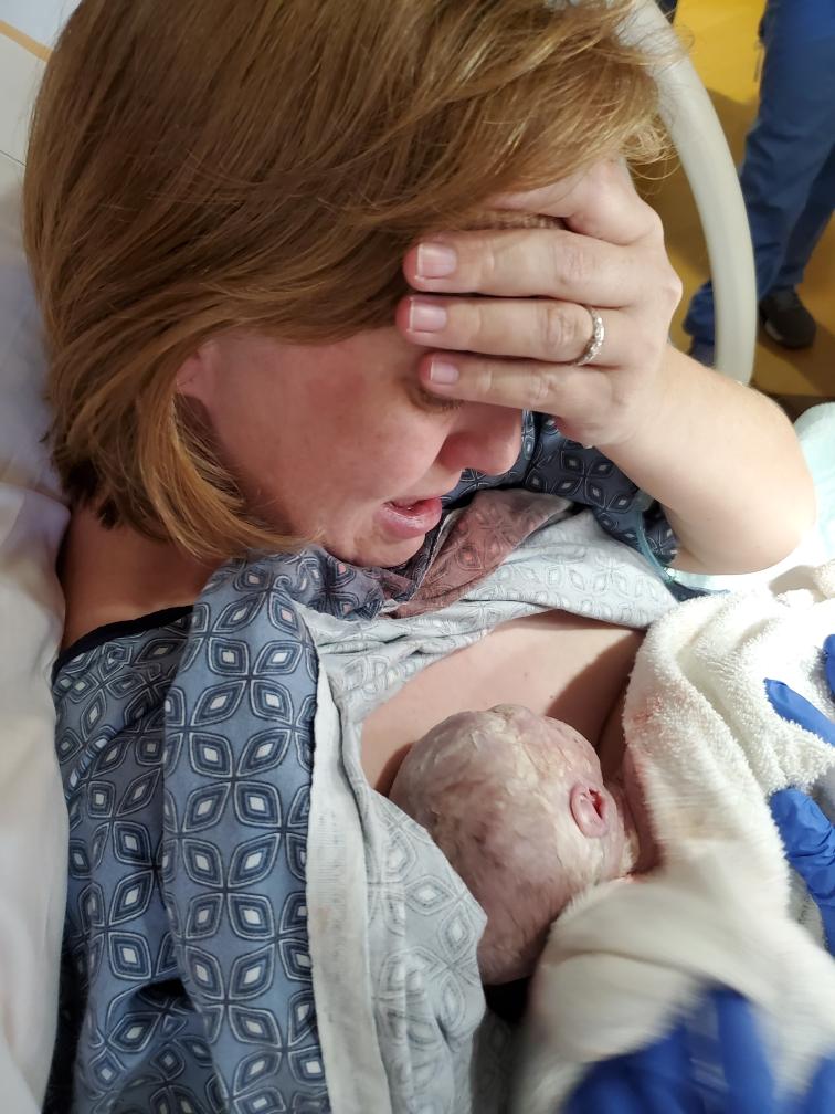 Megan holds Rockwell and cries right after his birth delivery.