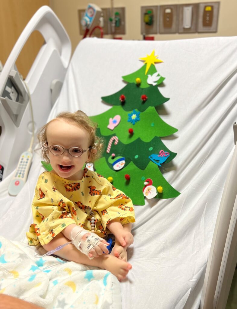 Two-year-old Rockwell sits in his inpatient hospital bed at Phoenix Children's