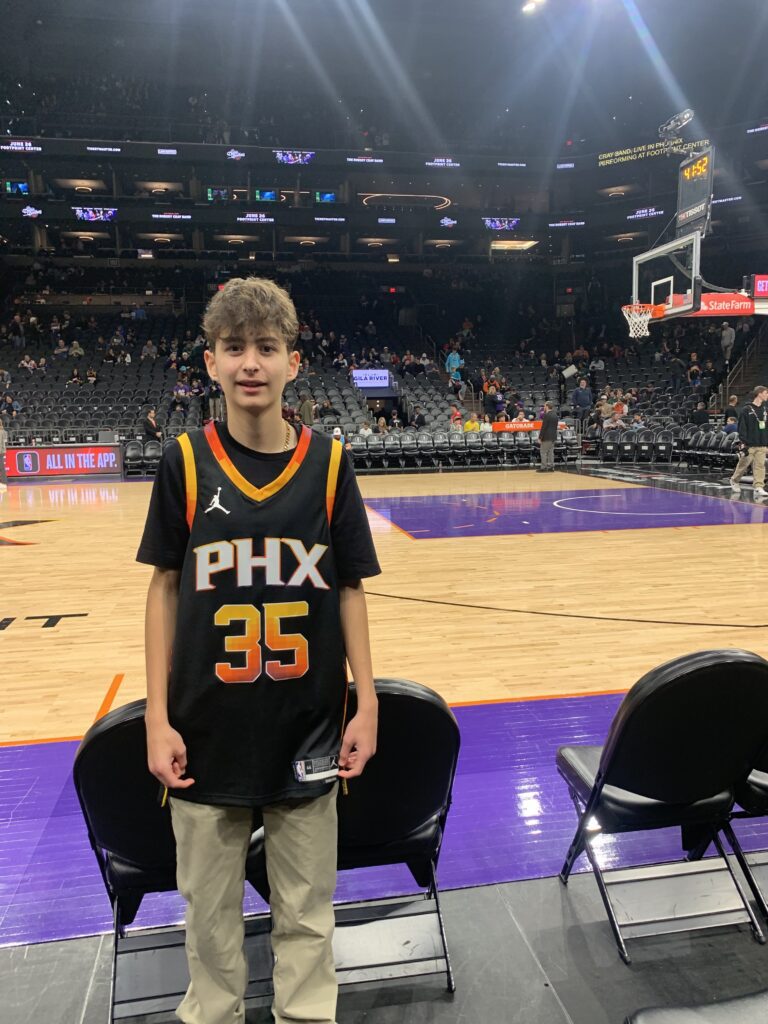 Calvin, wearing a Phoenix Suns jersey, on the court at the Footprint Center.