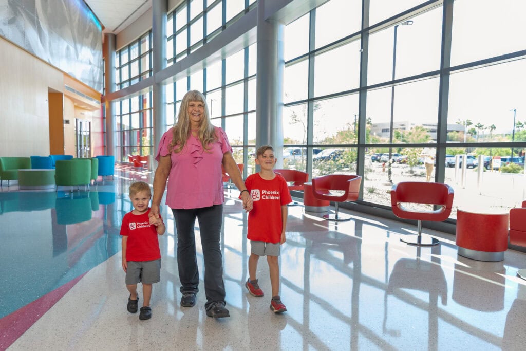 A grandmother walks through the lobby of Phoenix Children's with her two grandsons.