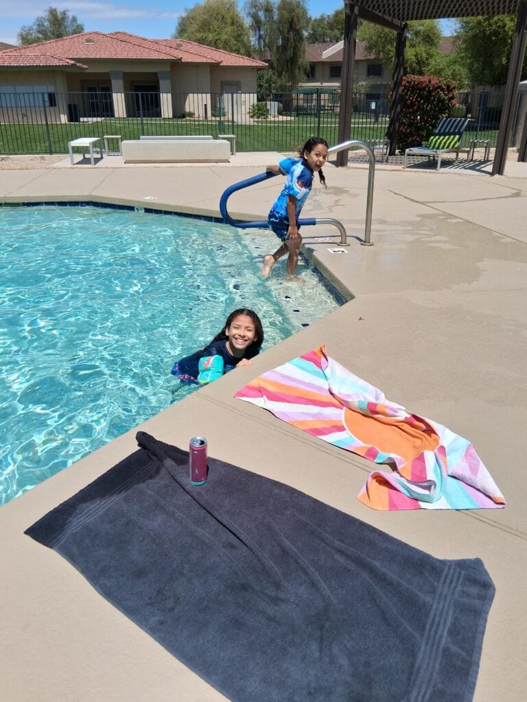 Phoenix Children's patient R.J. and a friend swim in an outdoor pool. 